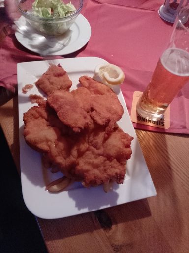 Frittierte Speisen auf einem Teller mit Salat und einem Glas Bier.